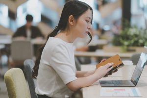 カフェでスマートフォン学習をする女性